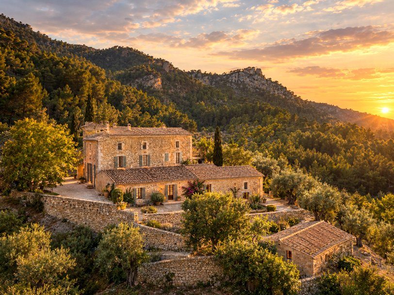 Stone possessió among olive terraces in the Serra de Tramuntana at sunset, Mallorca